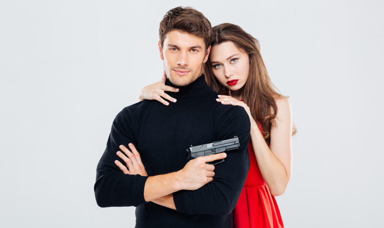Portrait of beautiful stylish young couple with gun