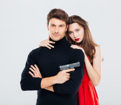 Portrait of beautiful stylish young couple with gun