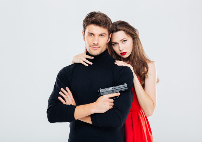 Portrait of beautiful stylish young couple with gun