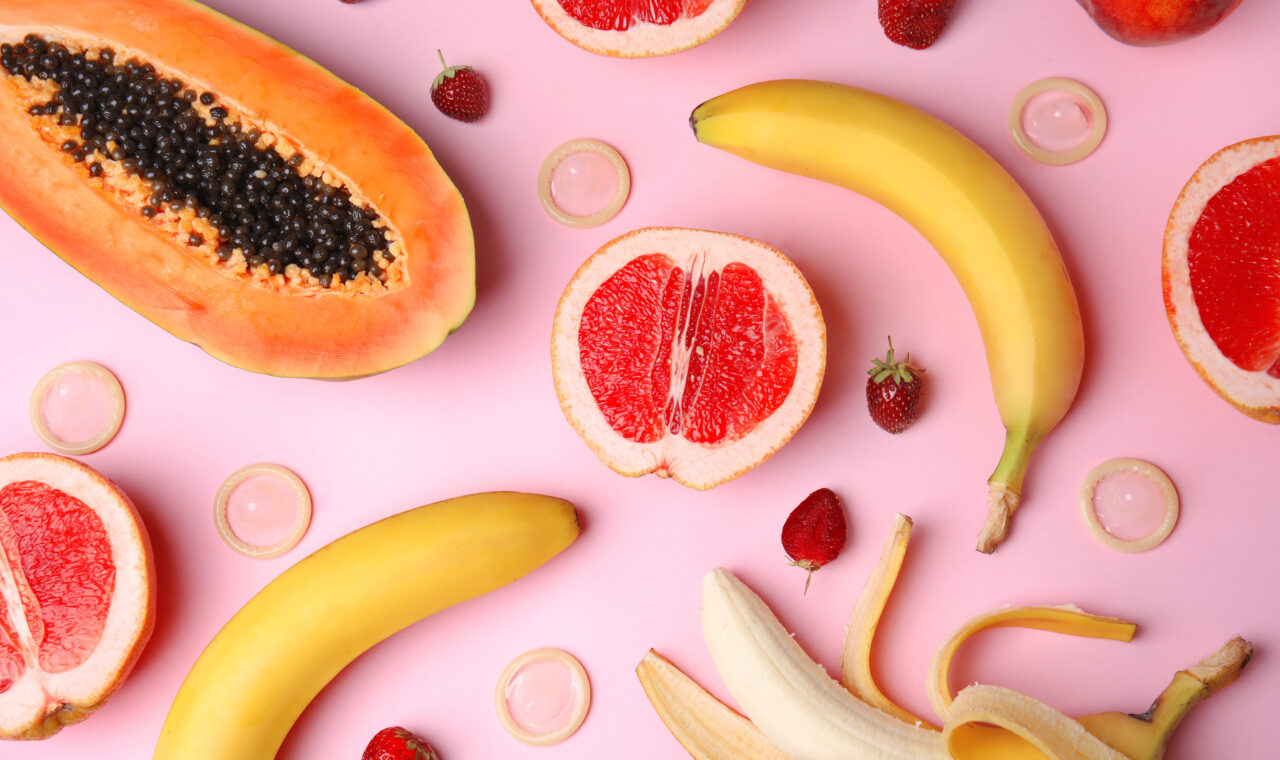 Flat lay composition with exotic fruits on pink background.