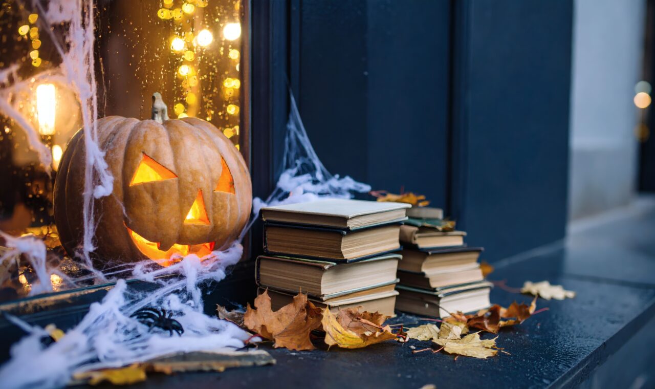 Glowing Jack-o'-Lantern, Cozy Setting with Books, Autumn Leaves, Indoor Ambiance