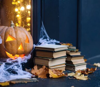 Glowing Jack-o'-Lantern, Cozy Setting with Books, Autumn Leaves, Indoor Ambiance