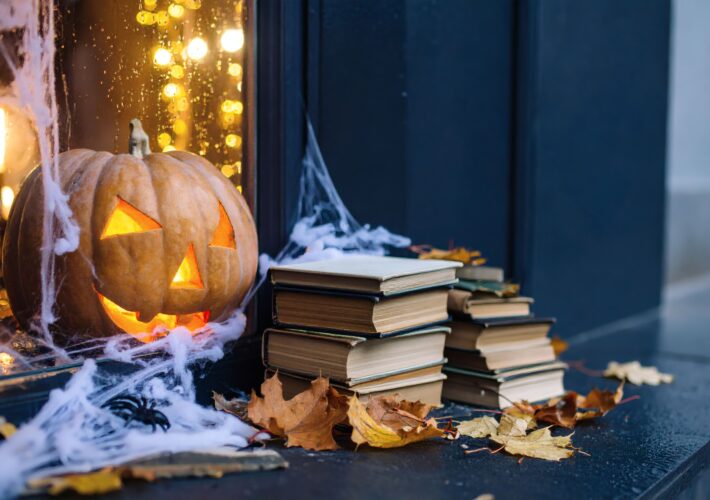 Glowing Jack-o'-Lantern, Cozy Setting with Books, Autumn Leaves, Indoor Ambiance